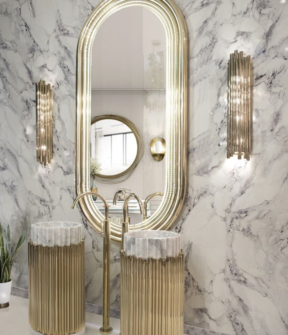 An oval wall mirror is the best choice to use with these golden bathrooms freestanding. An eclectic design in golden tones from the bathroom wall lights to the bathroom sinks.